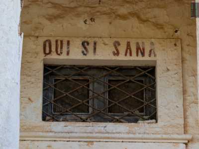 Sulla porta di ingresso, al di sopra di una grata in ferro rettangolare, leggiamo la scritta Qui si sana, un motto presente in tante ville e masserie dell�epoca